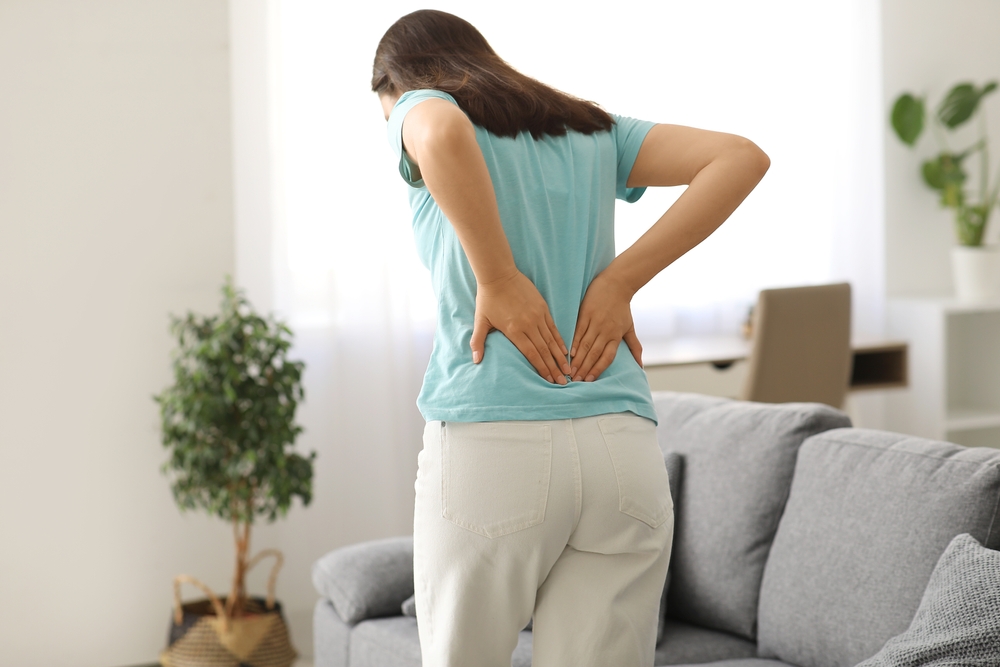 Young woman suffering from back pain