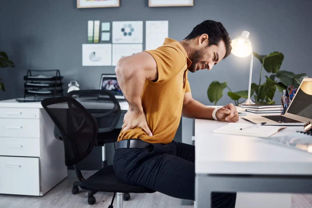 Man having lower back pain due to poor sitting posture
