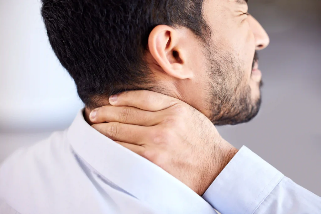Person holding the side of the neck due to a crick in the neck
