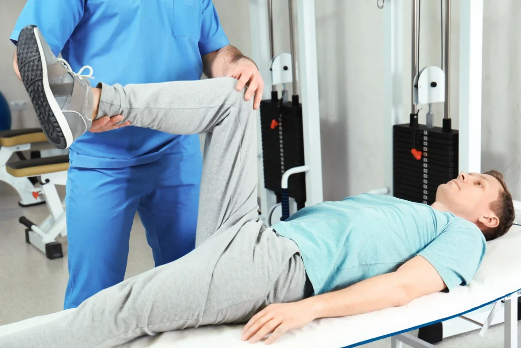 Chiropractor Helping Man with Leg exercises