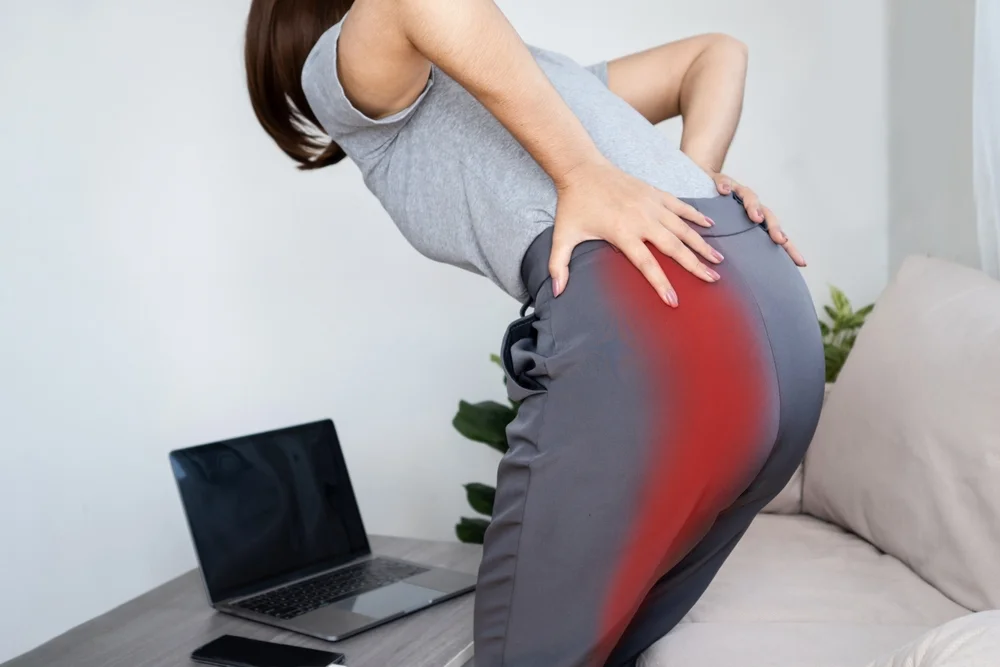 Woman experiencing sciatic nerve pain from buttock to leg