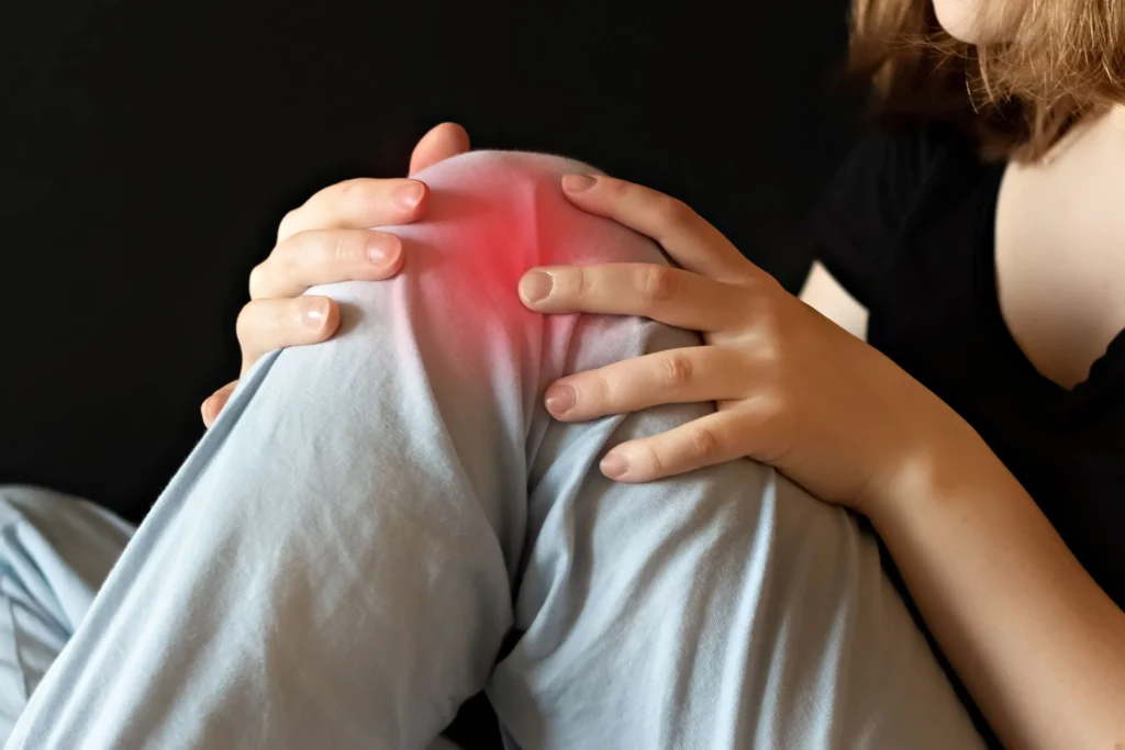 Woman Holding Knee Experiencing Pain and Discomfort