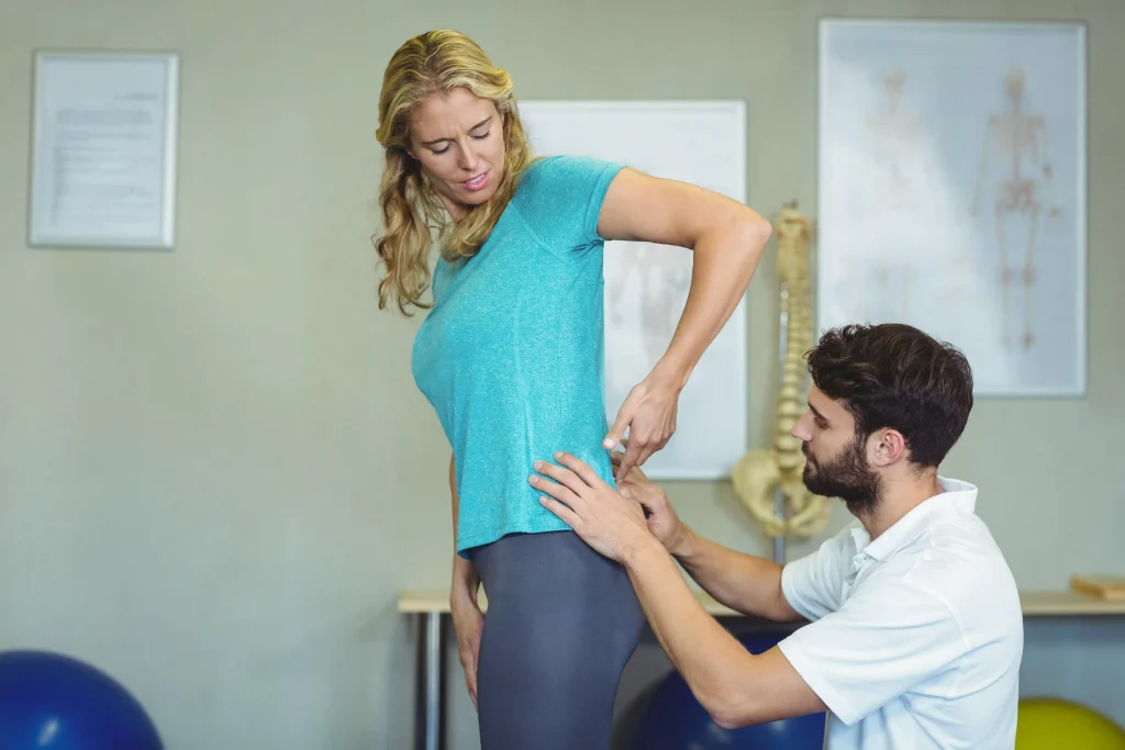 Chiropractor consulting with a female patient about hip pain